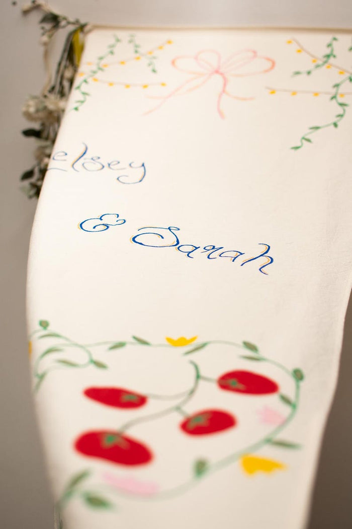 Couple names in blue script with floral and vine designs