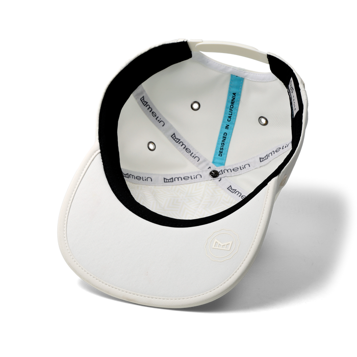 The inside view of the melin Split Crushed Fit Eagle Icon Hydro hat in egret