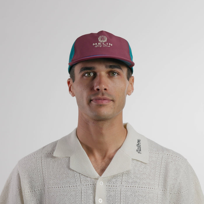 The model-image view of the melin Split Crushed Fit Eagle Links Clubhouse Hydro hat in grandeur