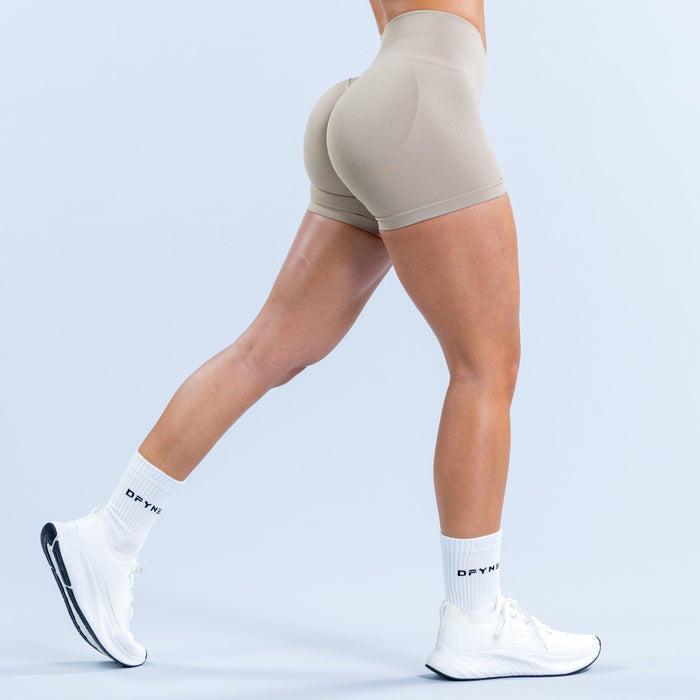 Light taupe fitted athletic shorts, side view with smooth stretch fabric