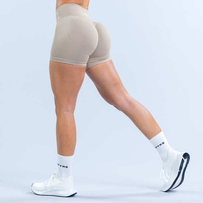 Light taupe fitted athletic shorts, rear view with contoured seams and logo