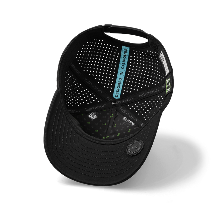 Black baseball cap with perforated ventilation panels, blue interior label, and adjustable back closure.