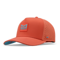 Hot coral baseball cap with perforated panels, blue logo patch on front, and teal undervisor.