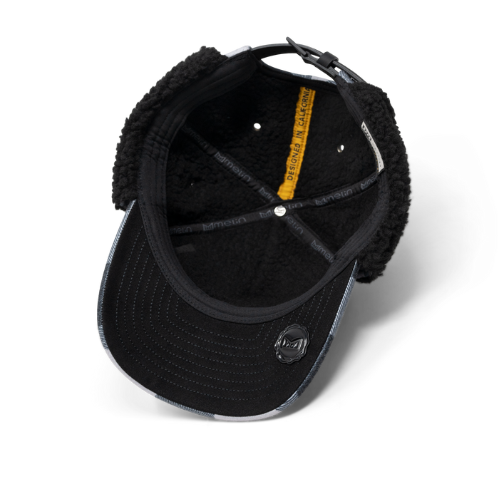 Black baseball cap with fleece-lined ear flaps, white striped side panels, and adjustable back closure shown from interior vi