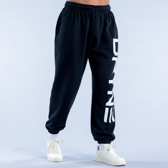 Dark cuffed jogger pants with white vertical logo stripe and ankle cuffs