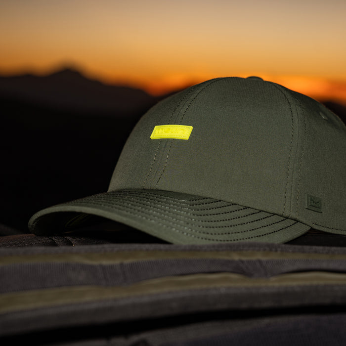 The melin Legend Hydro in Kombu Green against a sunset background