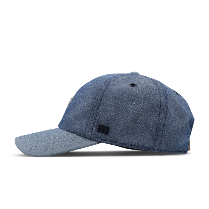 The side view of the melin The Legend Mill United Performance Dad Hat in chambray