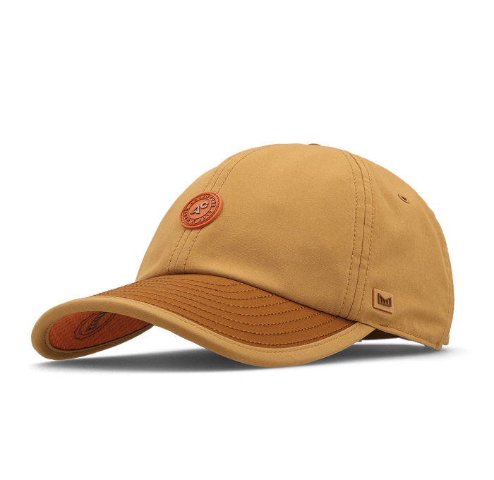 The front, angled view of the melin The Legend Packable Hydro Performance Dad Hat in Bone Brown