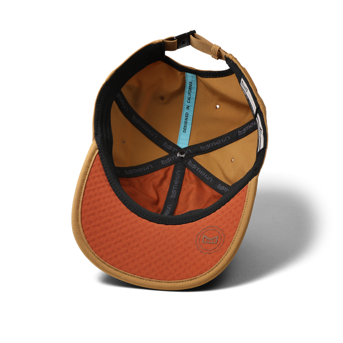 The bottom view of the melin The Legend Packable Hydro Performance Dad Hat in Bone Brown