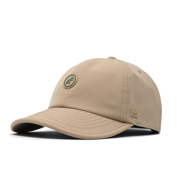 The front, angled view of the melin The Legend Packable Hydro  Performance Dad Hat in  Sand