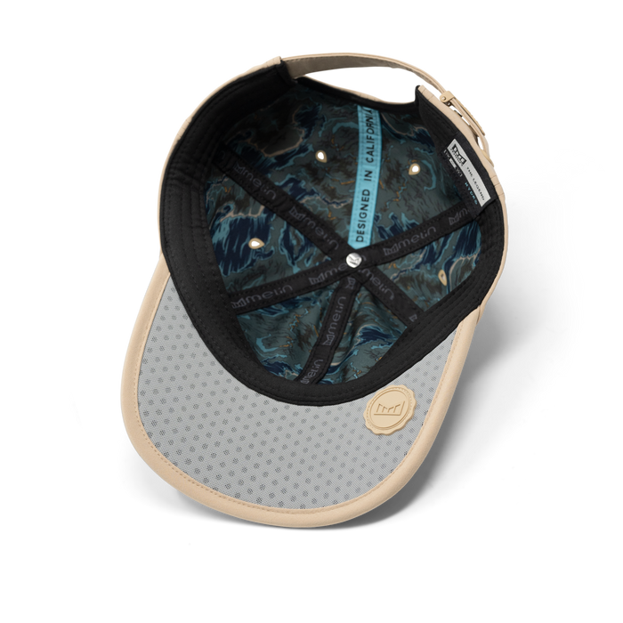 The inside view of the melin The Legend Packable Hydro  Performance Dad Hat in  Sand