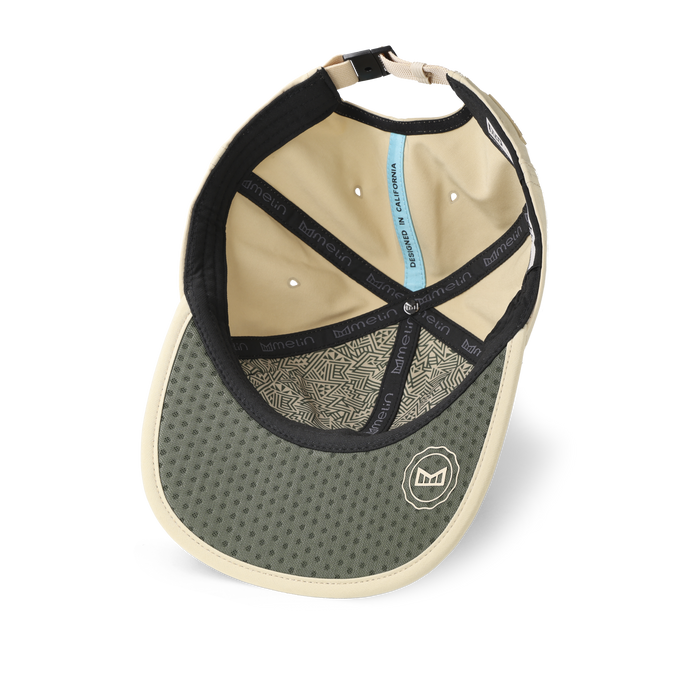 The inside view of the melin The Legend Packable Hydro Performance Dad Hat in sand