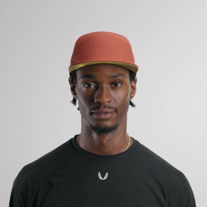 The model-image of the melin Horizon Fit Trenches Hydrolite hat in burnt brick