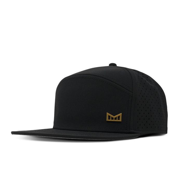 Black snapback cap with perforated side panels and small gold logo badge on front.