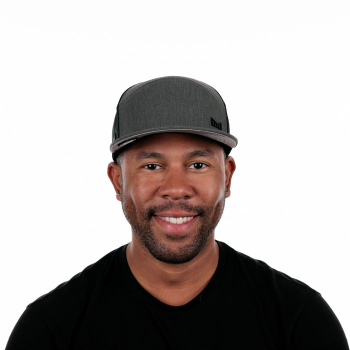 The model-image of the Melin Horizon Fit Trenches Icon Hydro hat in Heather Charcoal / Black