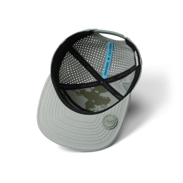 Shadow sage and black baseball cap with perforated mesh back, blue accent band, and circular logo on front.