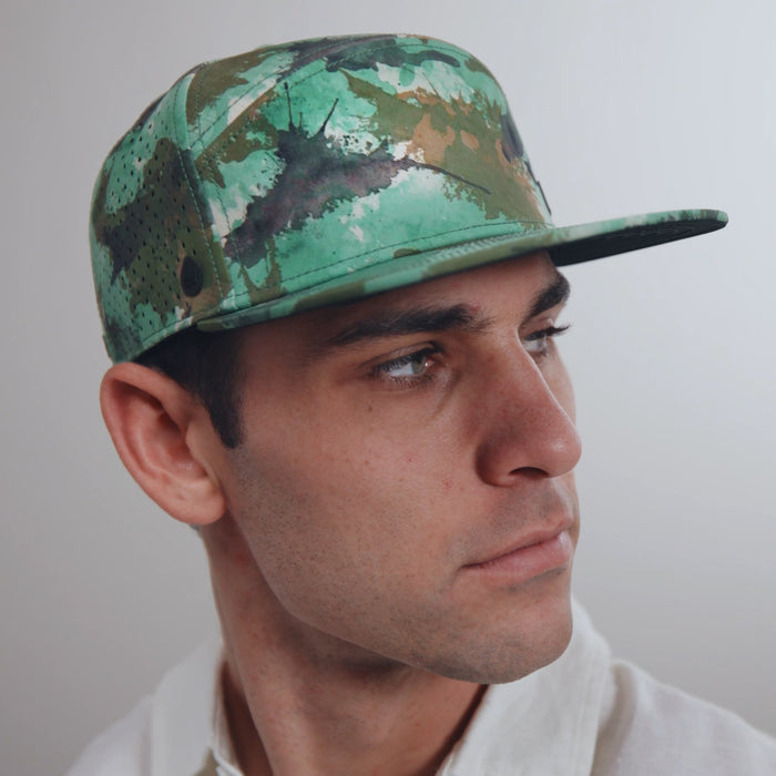 The model-image view of the melin Horizon Fit Trenches Icon Hydro hat in watercolor camo
