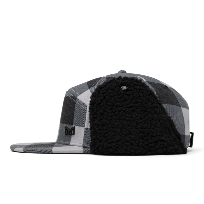 Black and white plaid baseball cap with black fleece lining and small logo patch on side.