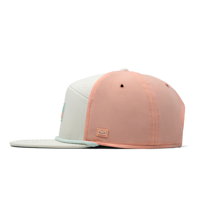 The side view of the melin Trenches Links Hydro  Horizon Fit in  Peach Nectar