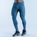 Blue unisex baselayer leggings with contoured seams and elastic waistband.
